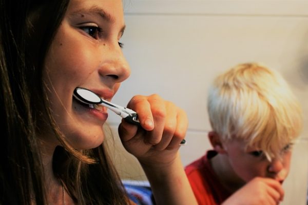 woman and kid brushing their teeth
