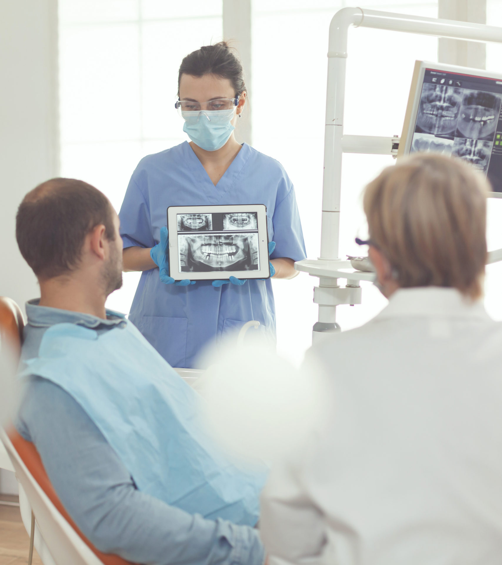 Orthodontist nurse holding digital tablet with tooth radiography on screen